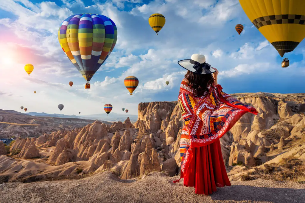 Girl watching hot air balloons at sunrise in Cappadocia, Turkey