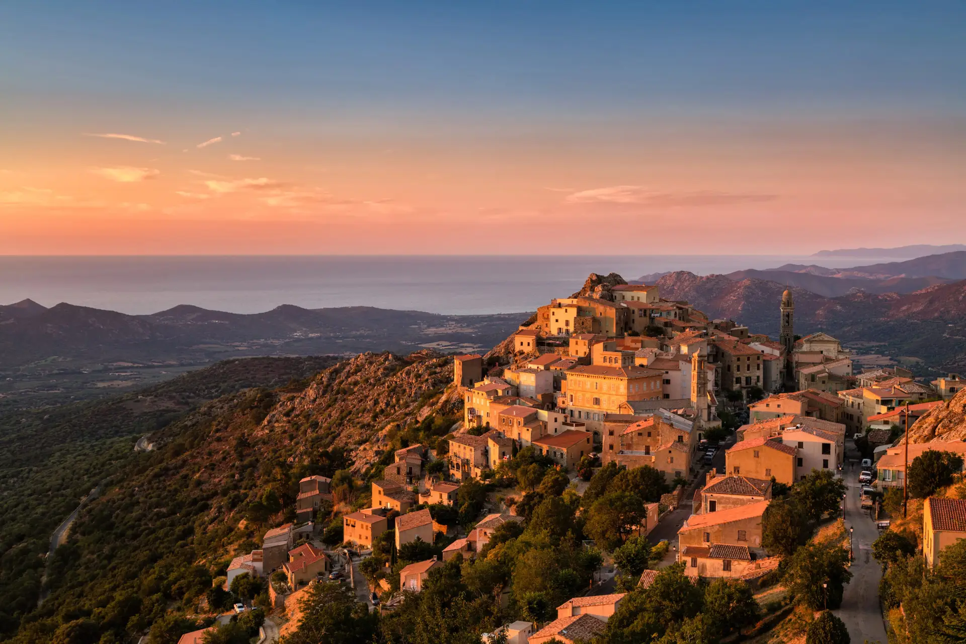 A peaceful mountain village in Corsica bathed in golden sunset light